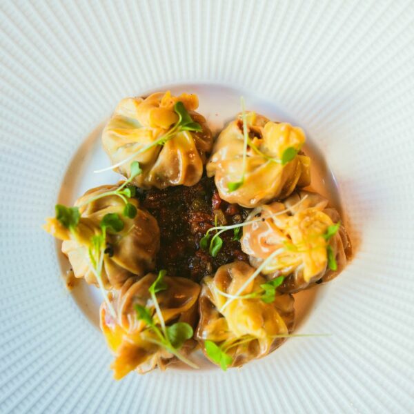Dumpling de pato sobre sala de ciruelas negras y sriracha