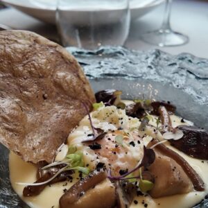 Huevo 63ºC sobre parmentier trufada y salteado de setas al pedro ximenez con teja de oreja de cerdo adobada